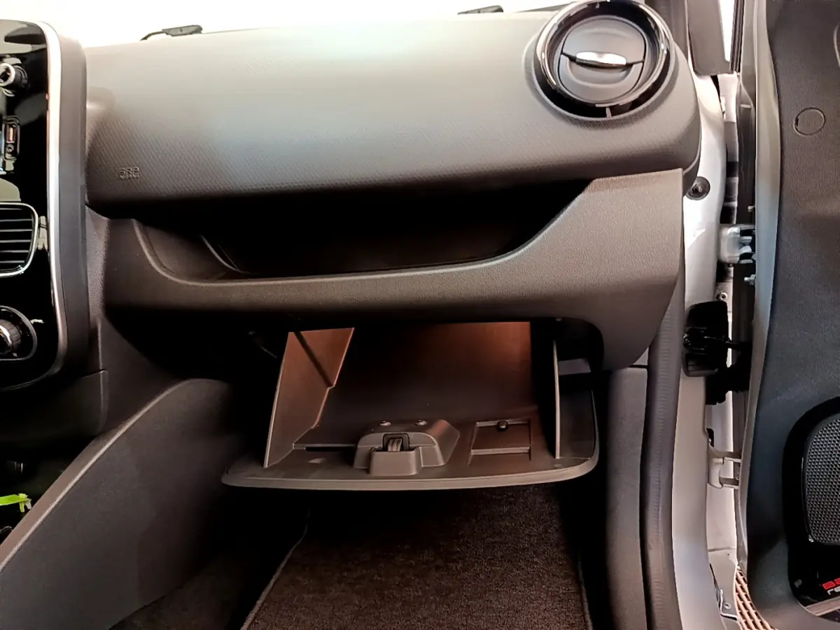 Gros plan sur la boîte à gants ouverte côté passager dans l'habitacle noir de la Renault Clio Business TCe 90 2019.