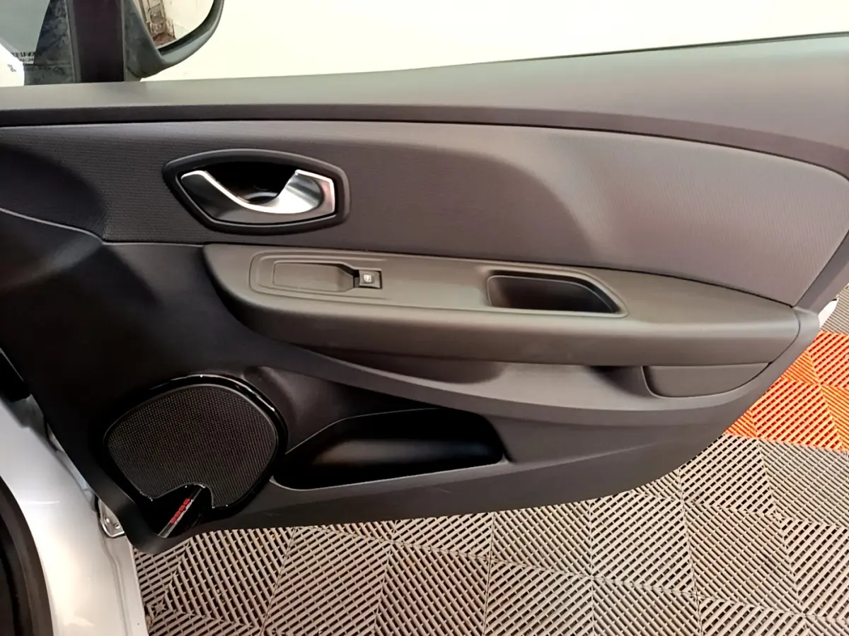 Vue rapprochée de la porte intérieure côté conducteur de la Renault Clio Business TCe 90 gris clair avec poignée argentée.