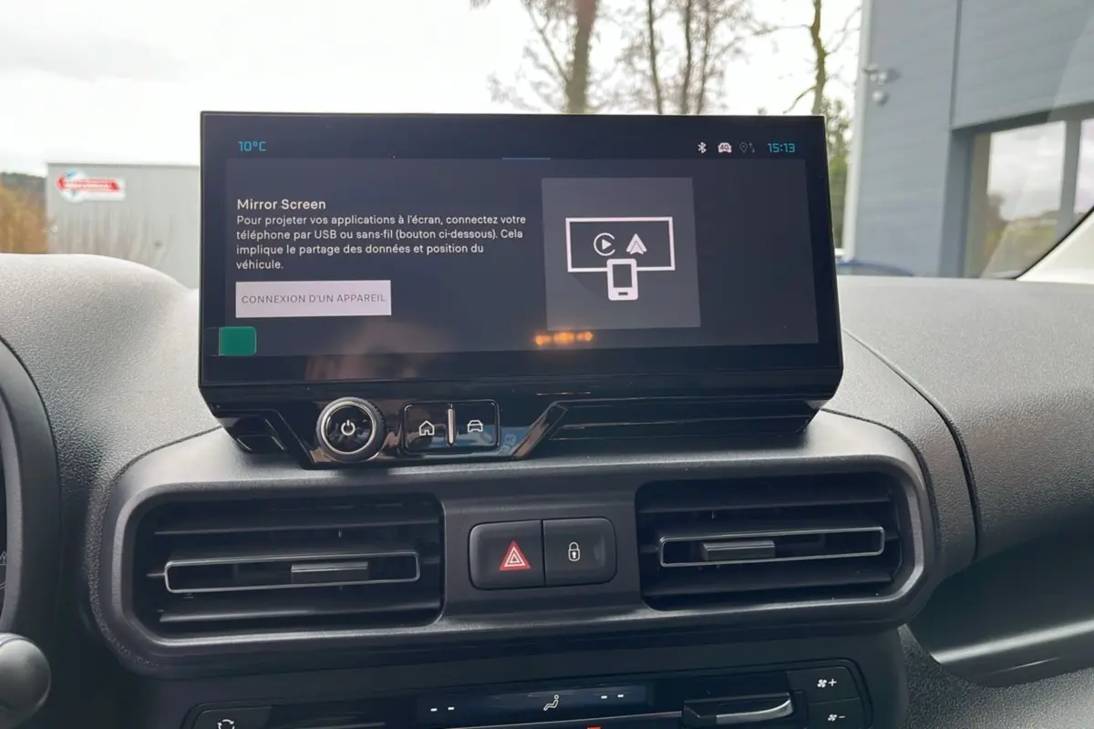 Vue frontale du tableau de bord du Citroën Berlingo blanc avec écran tactile central et commandes de climatisation.