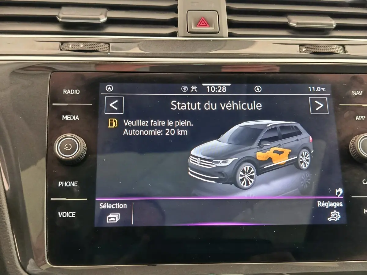Écran tactile du tableau de bord affichant le statut du Volkswagen Tiguan noir avec autonomie et alerte carburant.