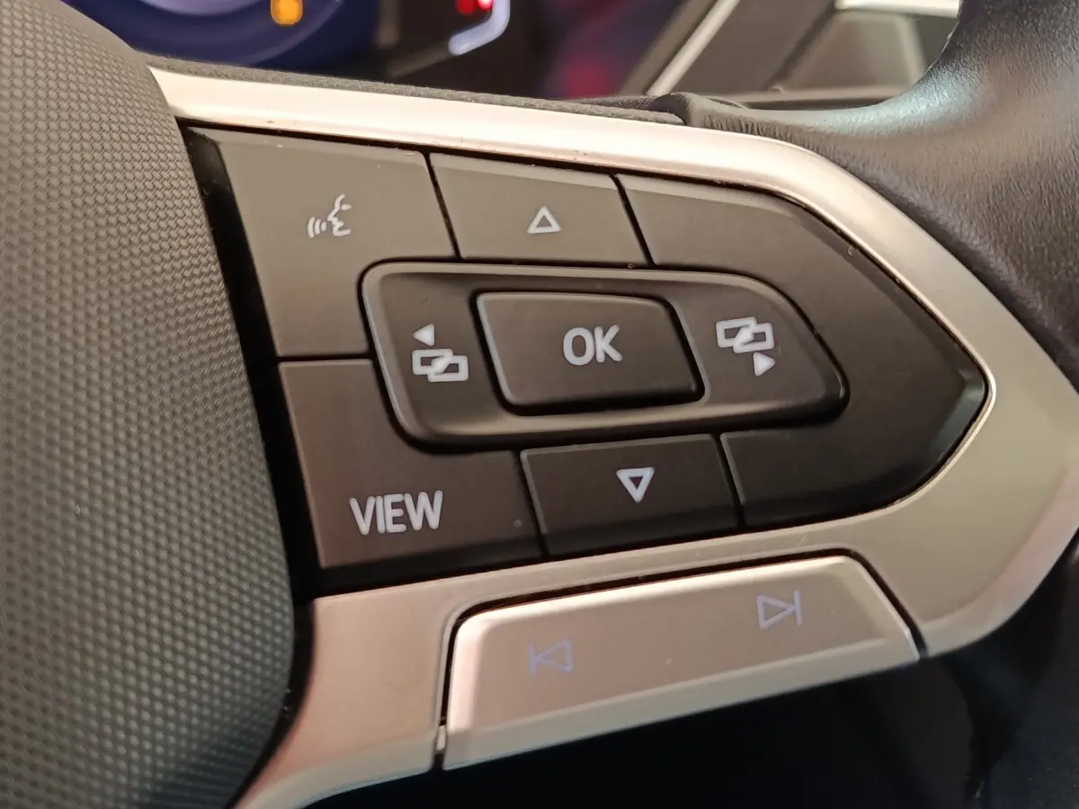 Gros plan sur les commandes multifonctions noires et argentées du volant du Volkswagen Tiguan 2.0 TDI 150 DSG7 Elegance.