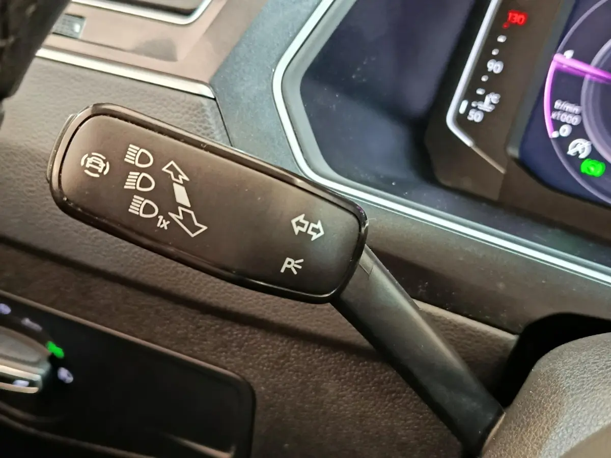 Gros plan sur la manette de clignotants noire à gauche du volant dans l’habitacle du Volkswagen Tiguan 2.0 TDI 2022.