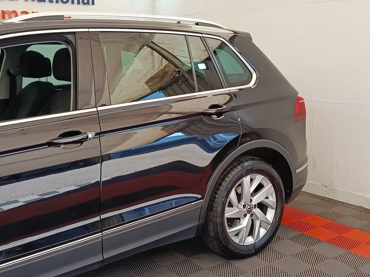 Vue latérale côté droit du Volkswagen Tiguan noir 2022, mettant en valeur les jantes alliage et les lignes de caisse chromées.