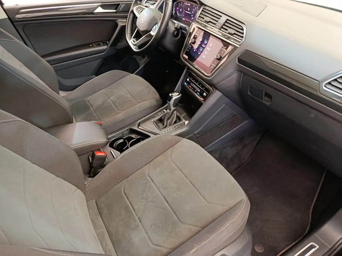 Vue intérieure côté conducteur du Volkswagen Tiguan 2.0 TDI 150 DSG7 Elegance avec sièges gris et tableau de bord numérique.
