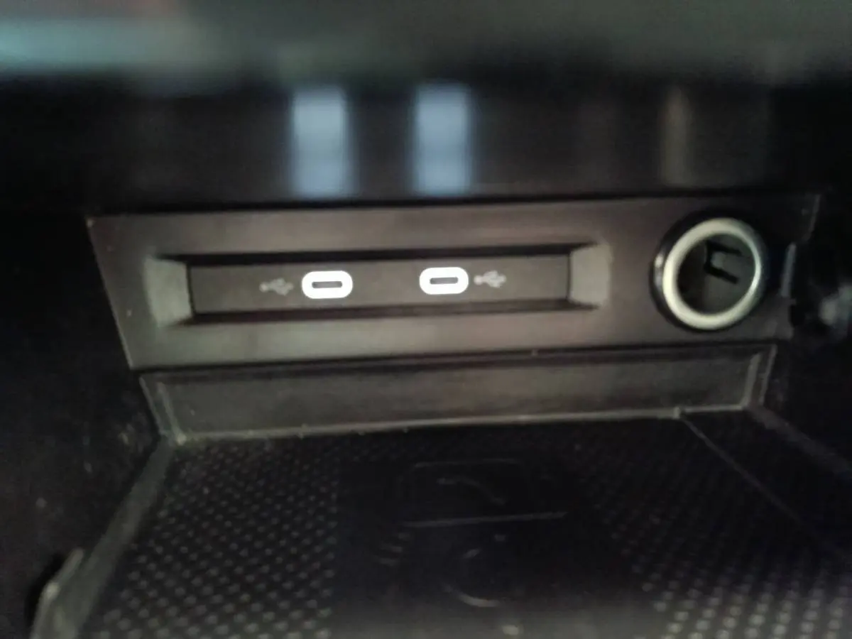 Gros plan sur la zone de recharge sans fil avec deux ports USB et prise 12V du Volkswagen Tiguan noir 2022.