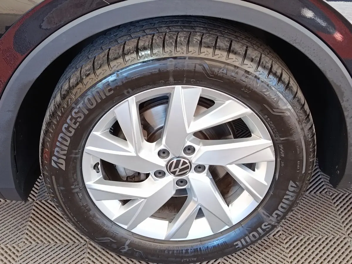 Gros plan sur la roue avant droite d’un Volkswagen Tiguan noir, jante alliage argentée et pneu Bridgestone visible.