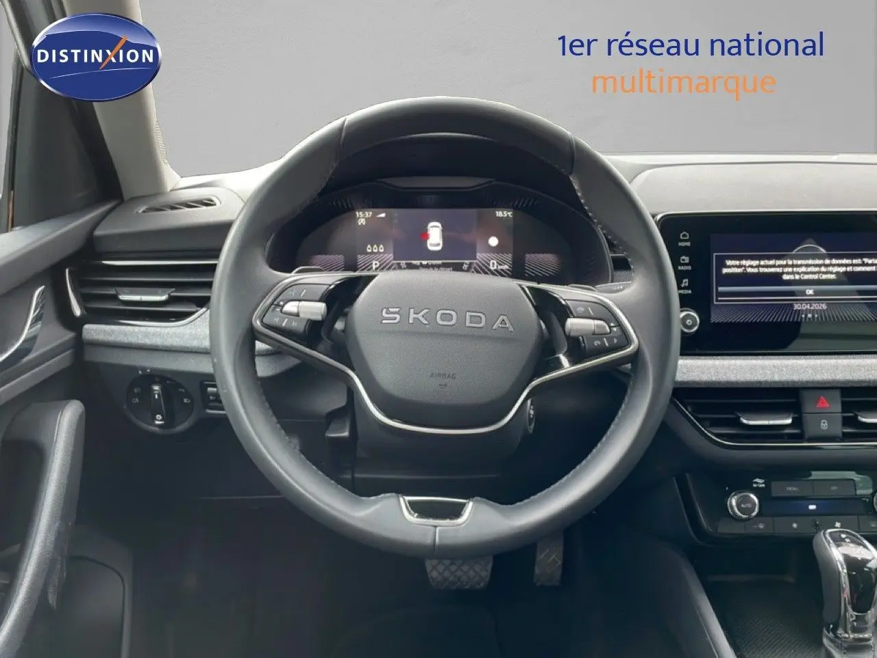 Vue intérieure centrée sur le volant SKODA du KAMIQ 2025, avec tableau de bord digital et écran tactile visible.