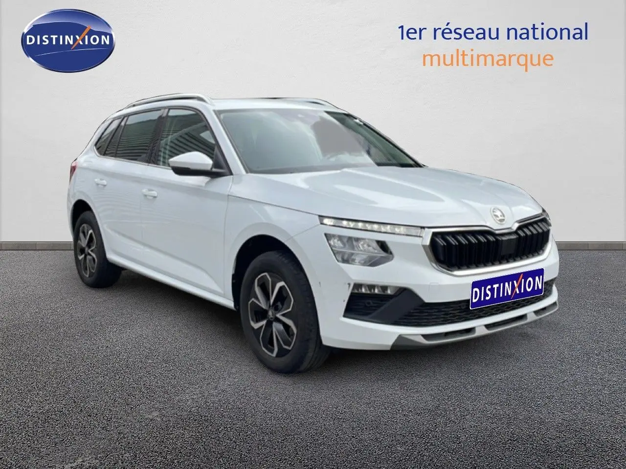 Vue 3/4 avant gauche d'un Skoda Kamiq blanc glacier avec calandre noire et jantes alliage distinctives.