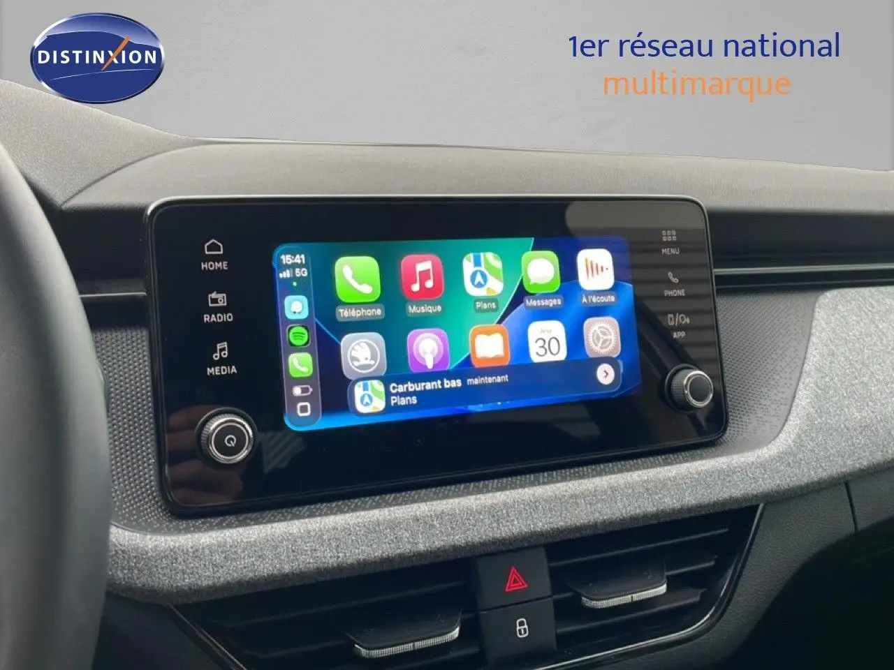 Écran tactile central du Skoda Kamiq blanc glacier 2025, affichant interface smartphone connectée, tableau de bord gris texturé.