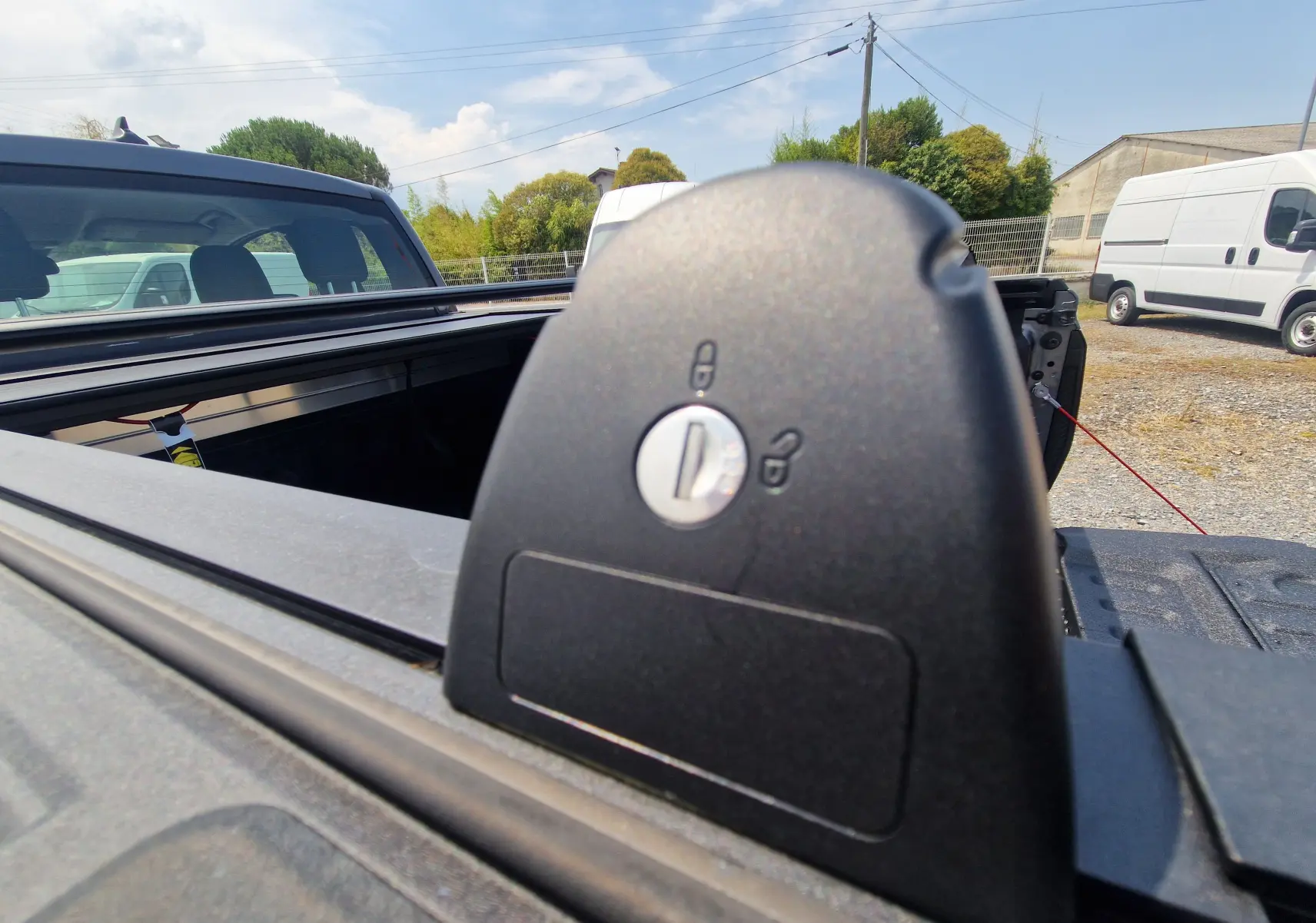 Gros plan sur le verrouillage du rideau de plateau rigide du Ford Ranger Super Cabine gris carbone, vue arrière ouverte.