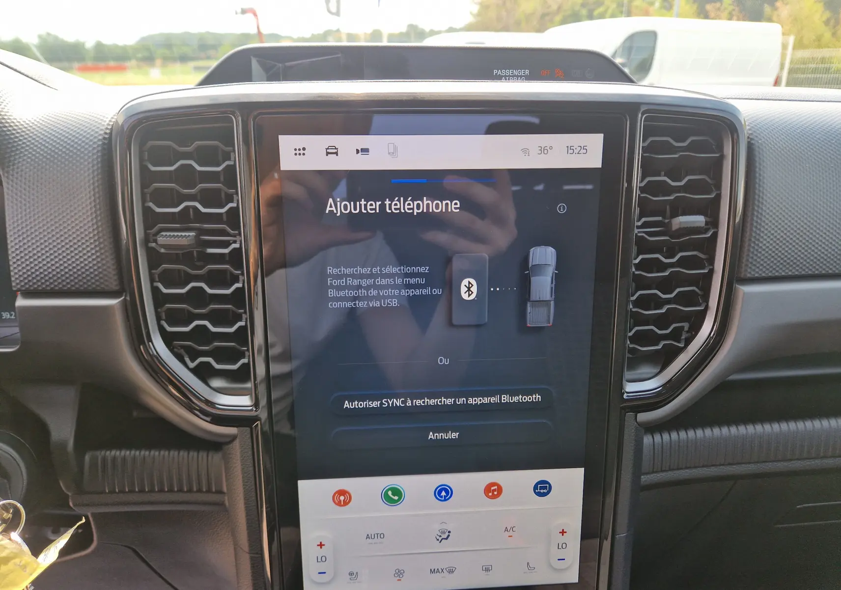 Vue intérieure centrée sur l'écran tactile 12,4'' du Ford Ranger Super Cabine gris carbone avec commandes climatisation visibles.