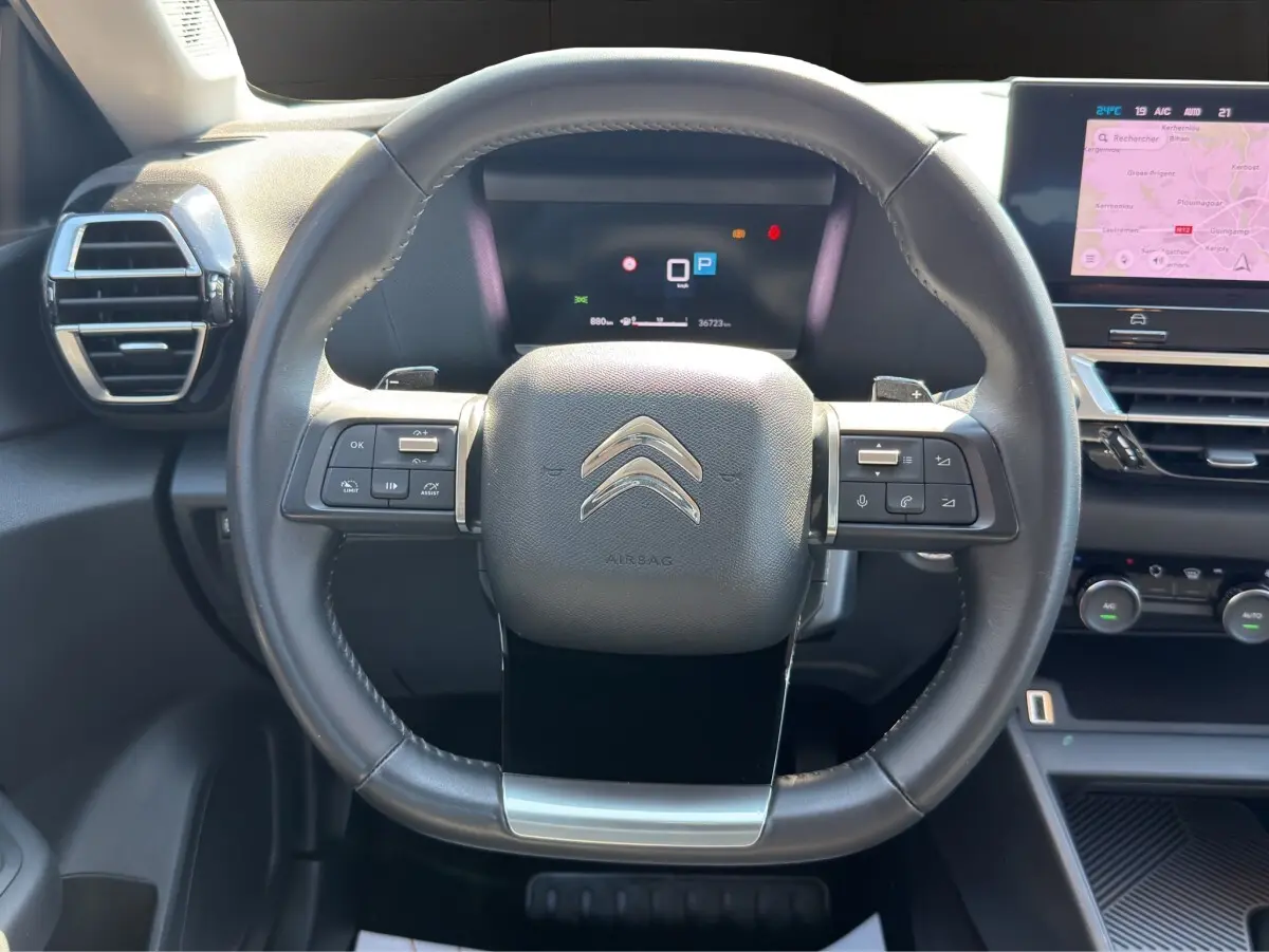 Volant cuir multifonctions Citroën C4 2023 vu de face avec tableau de bord numérique et écran tactile navigation.