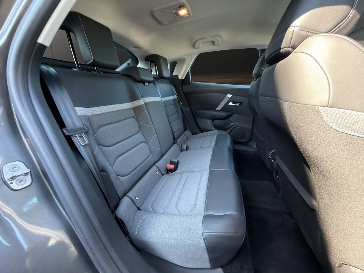 Vue intérieure côté gauche des sièges arrière gris clair et cuir noir d'une Citroën C4 gris foncé 2023.