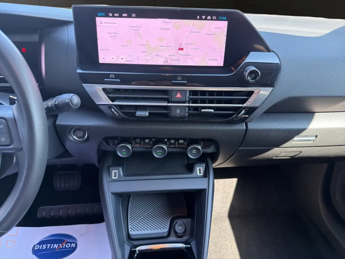 Vue intérieure du tableau de bord et console centrale de la Citroën C4 2023 avec écran tactile de navigation allumé.
