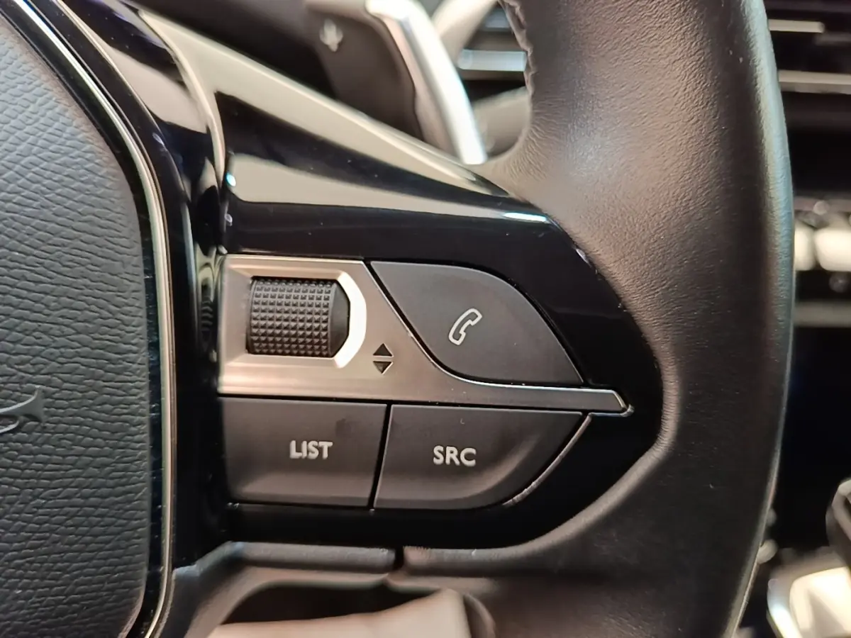 Gros plan sur les commandes multifonctions du volant cuir noir du Peugeot 3008 PureTech 130 S&S EAT8 Allure.