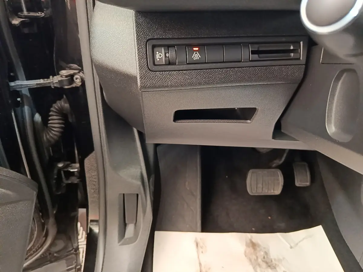 Vue intérieure côté conducteur du Peugeot 3008 noir, montrant les pédales et commandes sous le tableau de bord.