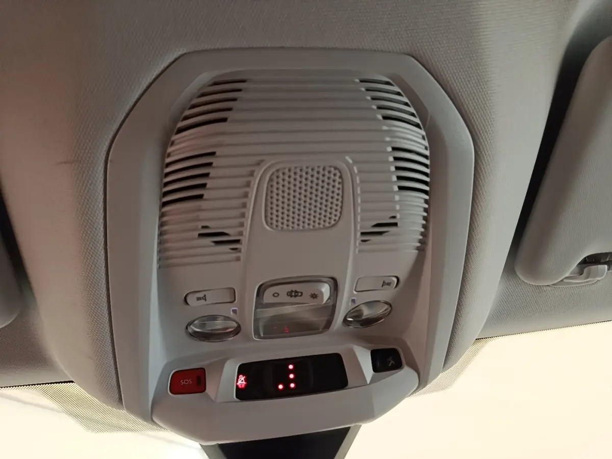 Vue en gros plan du plafonnier intérieur gris clair du Peugeot 3008 noir, avec boutons SOS et éclairage.