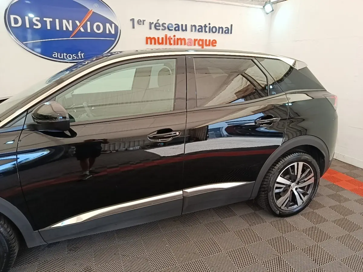 Profil côté gauche du Peugeot 3008 noir avec jantes alliage et détails chromés sous les portes, en intérieur showroom.