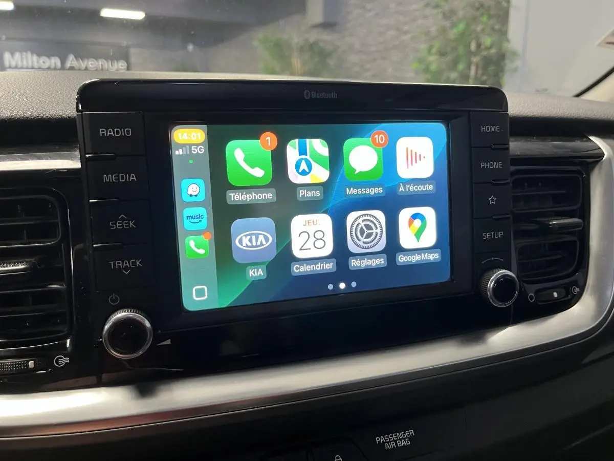 Écran tactile central 7 pouces du Kia Stonic 2019 affichant Apple CarPlay avec commandes autour en finition noire.