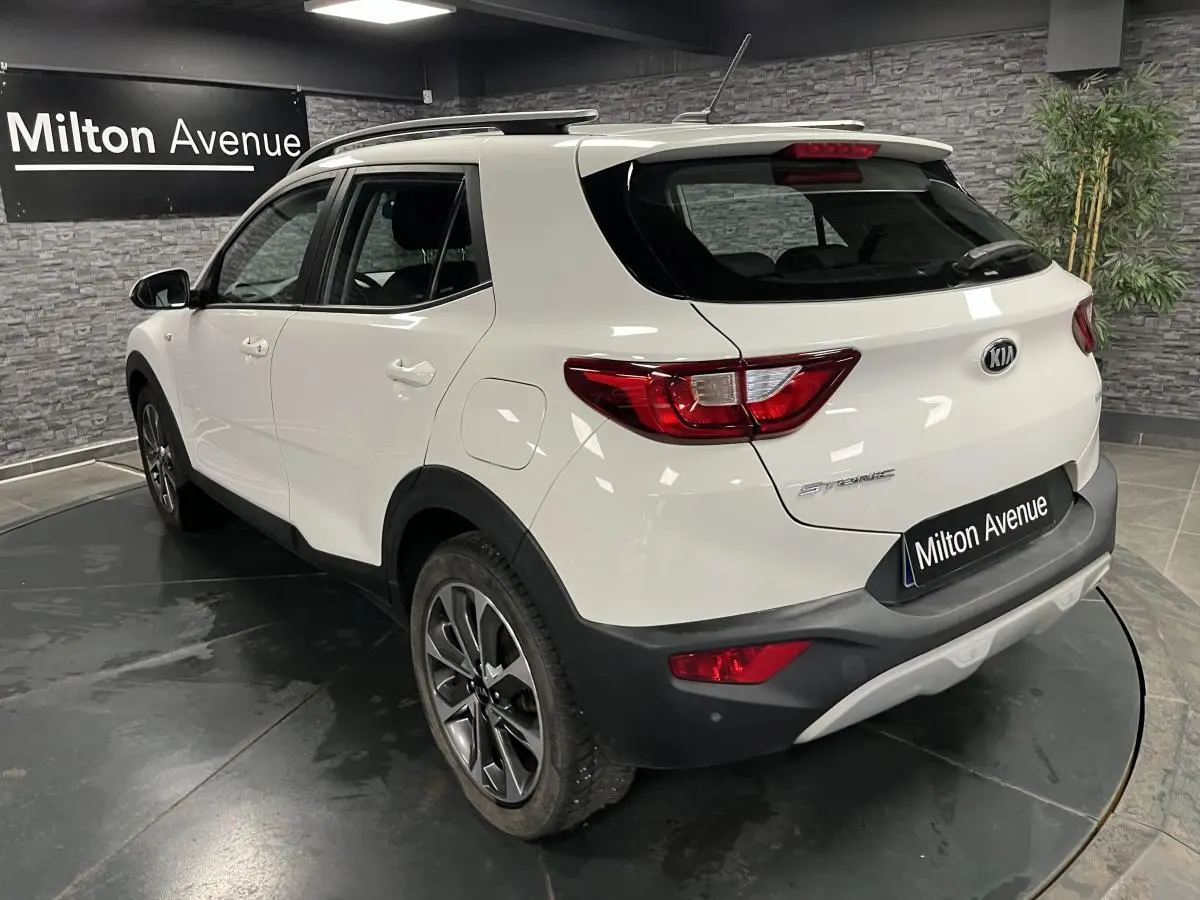 Vue 3/4 arrière droite du KIA Stonic blanc avec jantes alliage et détails noirs sur boucliers et passages de roues.
