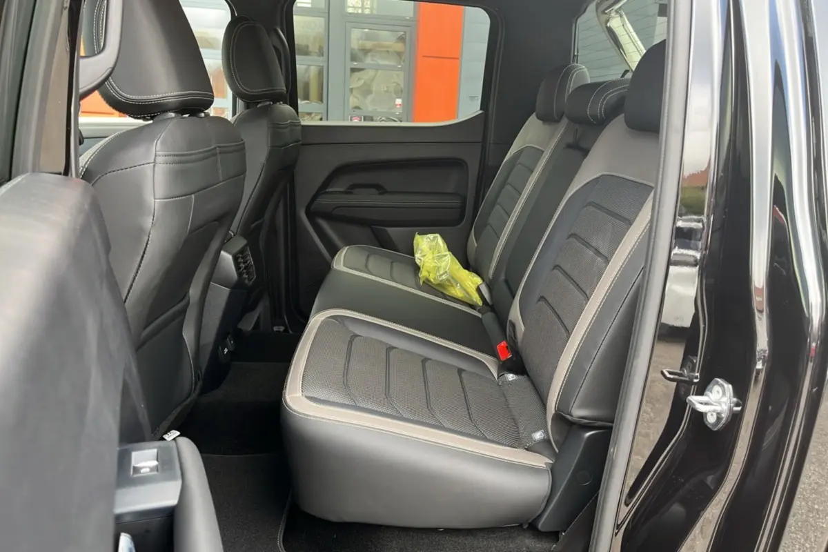 Vue intérieure côté droit sur les sièges arrière en cuir noir et gris du Volkswagen Amarok Simple Cabine 2025.