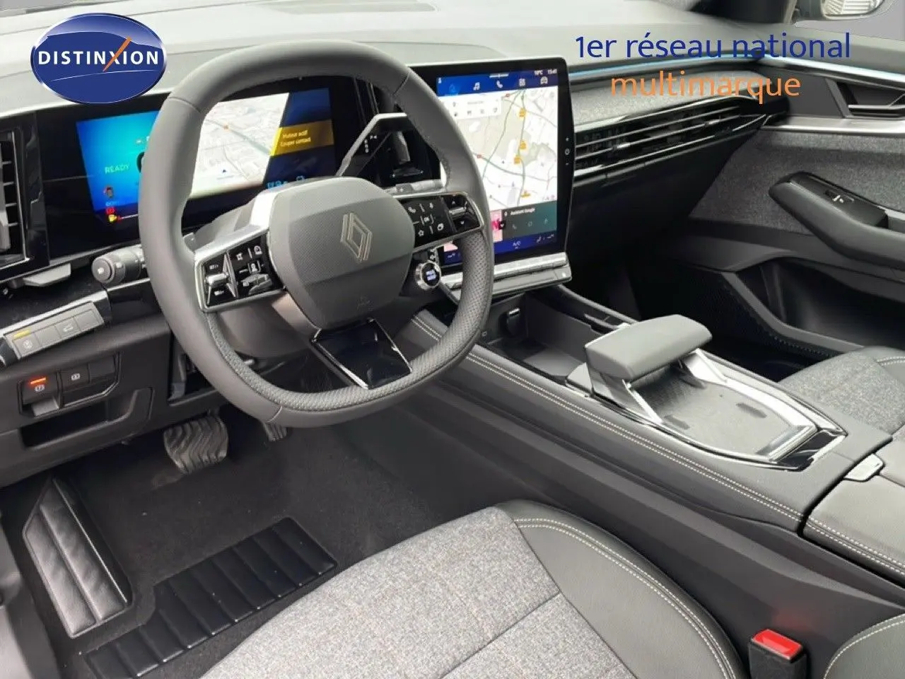 Vue intérieure côté conducteur du Renault Espace 2025, tableau de bord numérique et sellerie tissu gris avec inserts cuir noir.