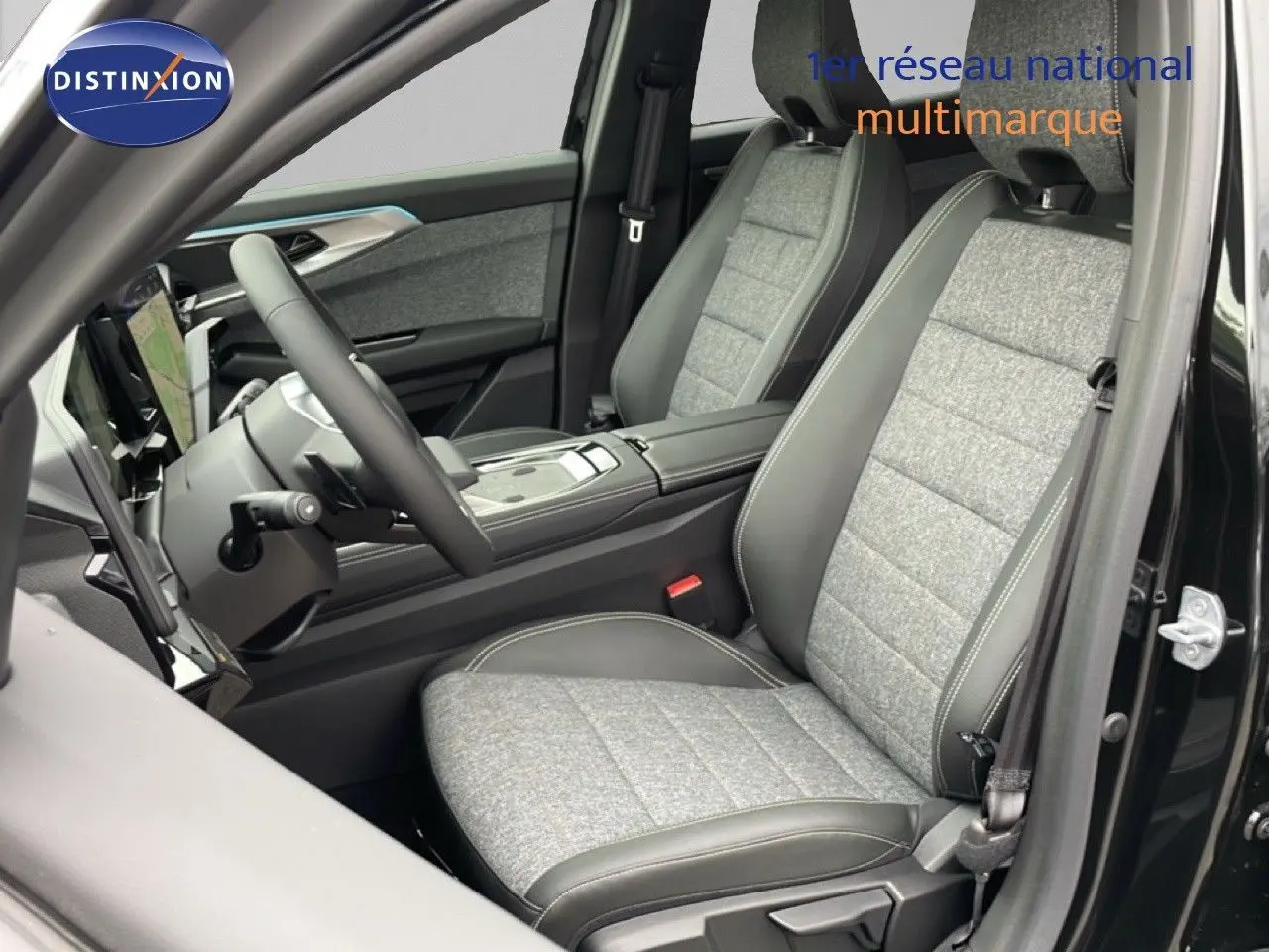 Vue intérieure côté conducteur du Renault Espace 2025 noir étoile métal, sièges tissu gris avec cuir noir et tableau de bord moderne.