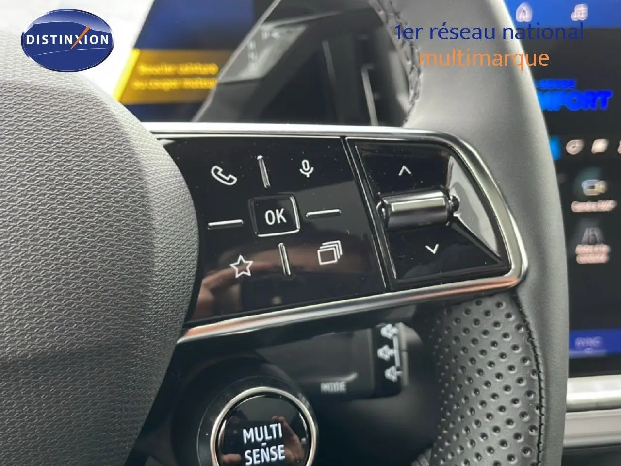 Gros plan sur le volant noir perforé du Renault Espace 2025, avec commandes multifonctions et bouton Multi-Sense visible.