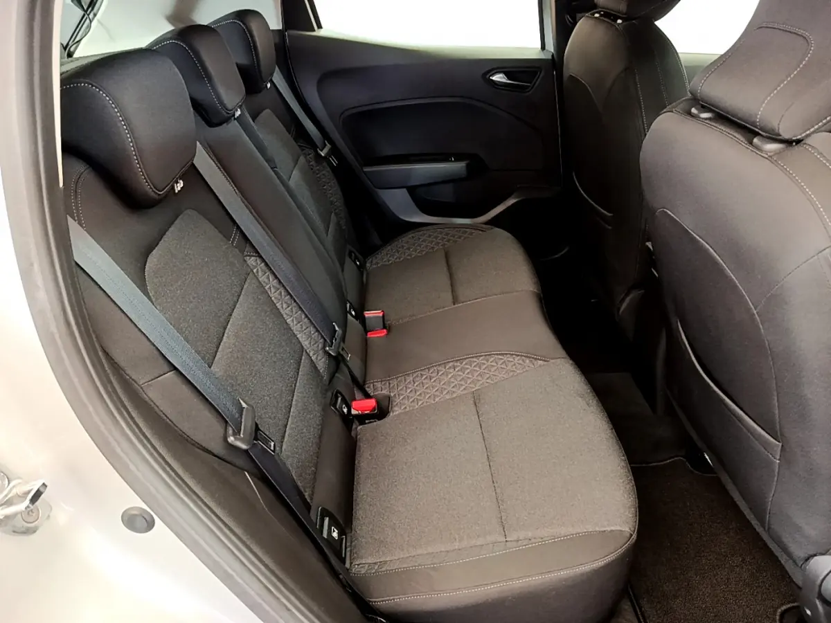 Vue intérieure côté arrière droit de la Renault Clio Business TCe 100 2020 avec sièges tissu gris foncé et ceintures visibles.