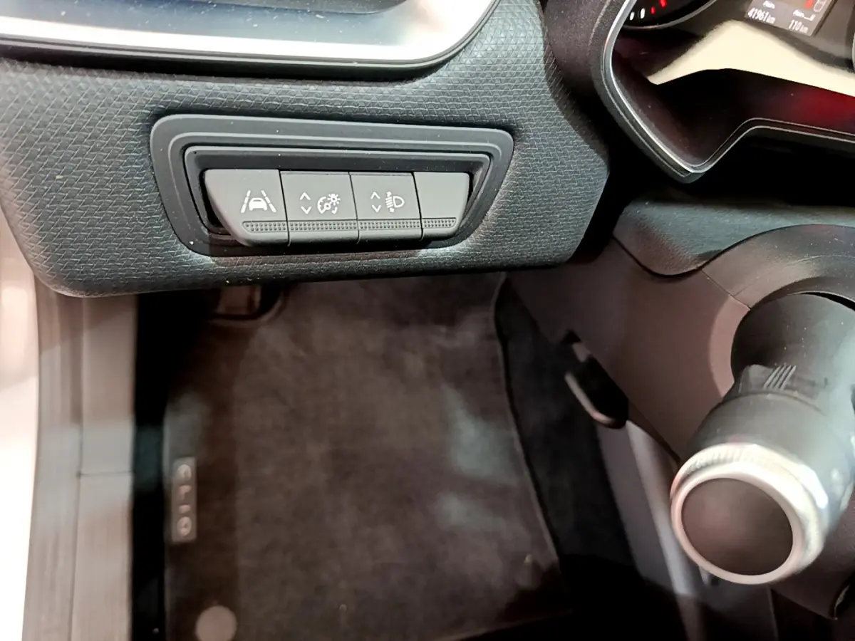 Vue rapprochée du tableau de bord côté gauche de la Renault Clio Business TCe 100, avec commandes d'assistance et volant partiel.