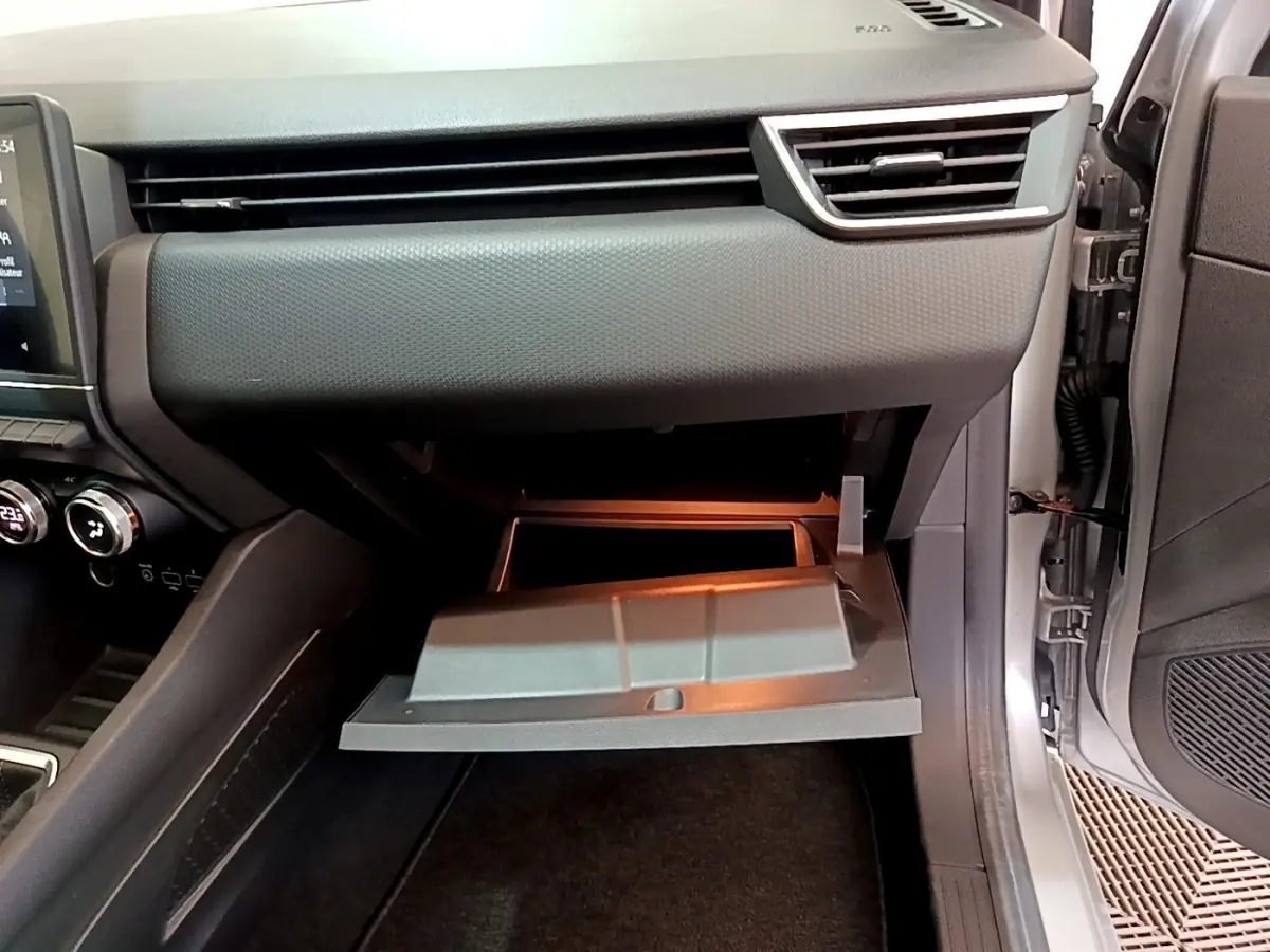 Vue intérieure côté passager de la Renault Clio Business TCe 100 2020, boîte à gants ouverte et tableau de bord gris clair.