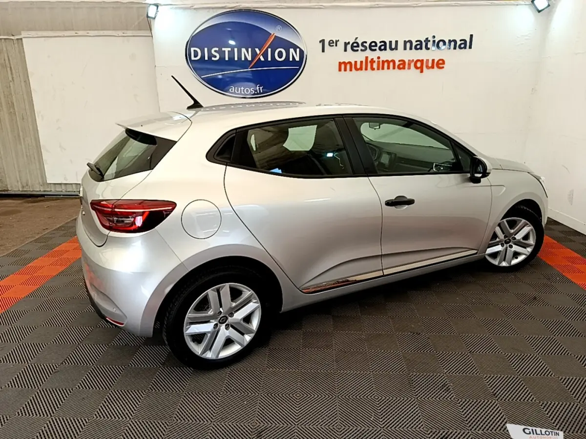 Renault Clio Business TCe 100 gris clair vue de profil côté gauche dans un showroom avec sol à damier noir et orange