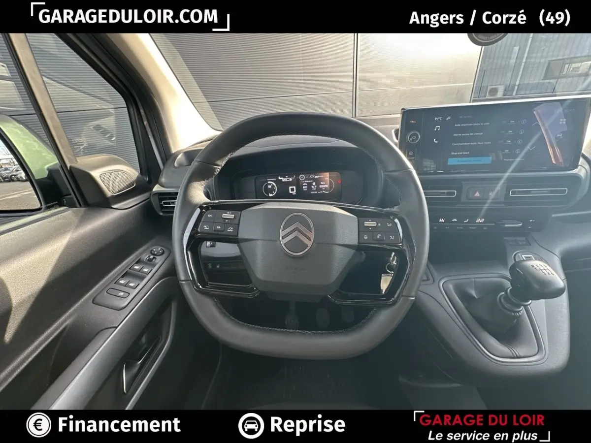 Vue intérieure centrée sur le volant cuir multifonctions et le tableau de bord numérique du Citroën Berlingo gris clair 2024.