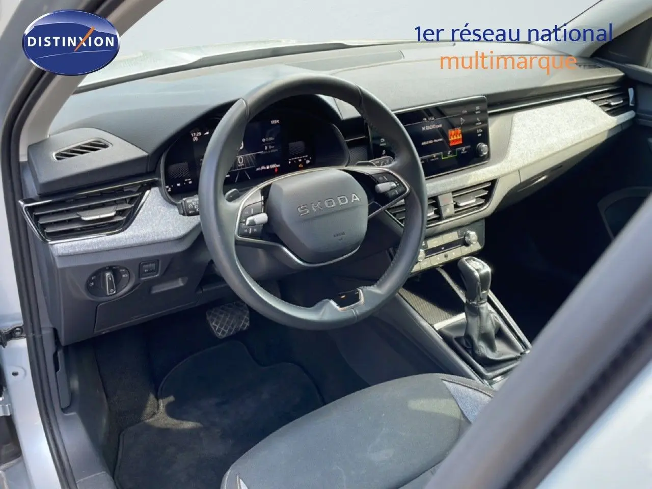 Vue intérieure côté conducteur du Skoda Kamiq gris argent, avec tableau de bord digital et volant multifonction.
