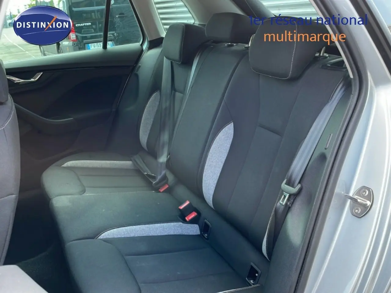 Vue intérieure arrière côté droit du Skoda Kamiq 2025 gris argent, sièges tissu noir avec inserts gris clair.