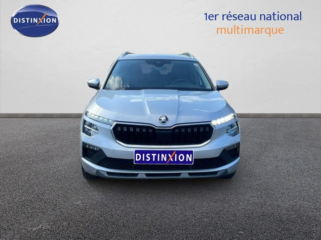 Vue avant d'un Skoda Kamiq gris argent métallisé 2025 avec calandre noire et feux LED allumés.