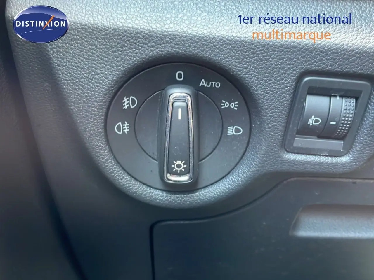 Gros plan sur le bouton de commande des phares du Skoda Kamiq gris argent, intérieur noir texturé.
