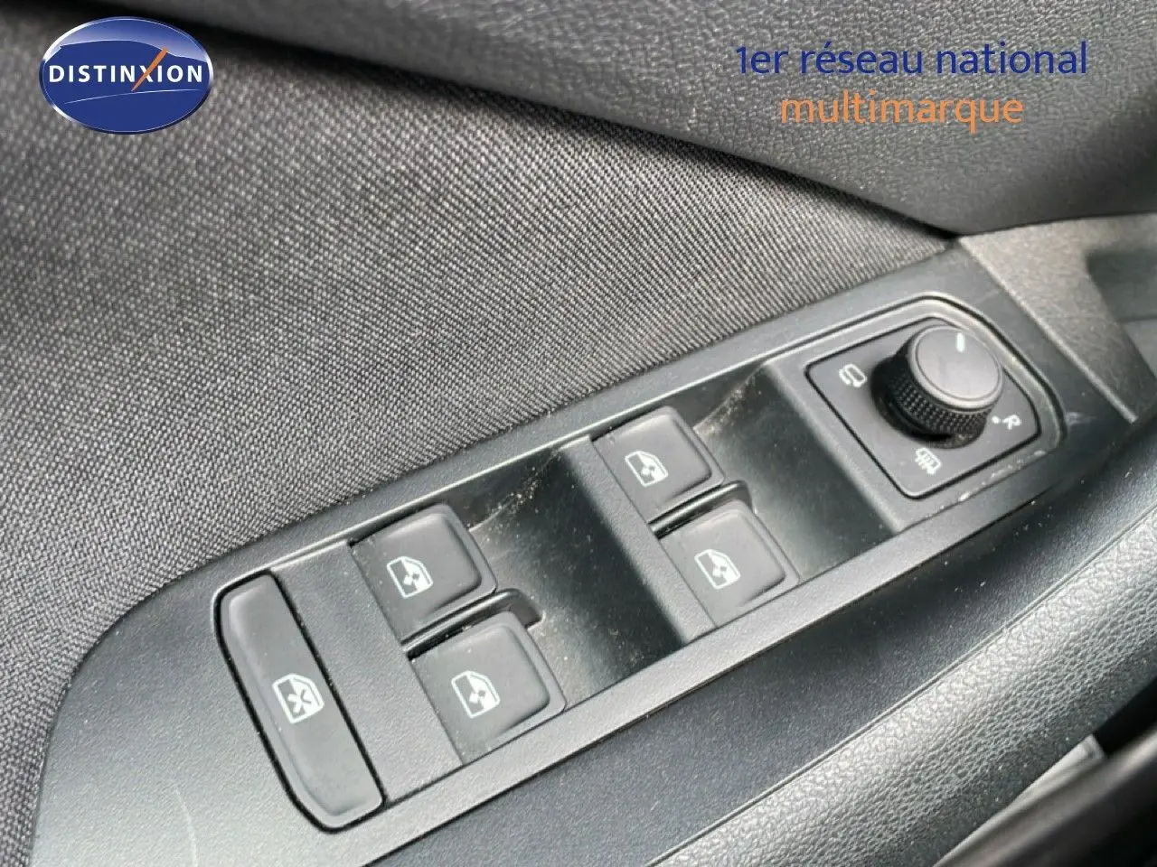 Gros plan sur les commandes des vitres électriques et rétroviseurs du côté conducteur d’un Skoda Kamiq gris argent 2025.