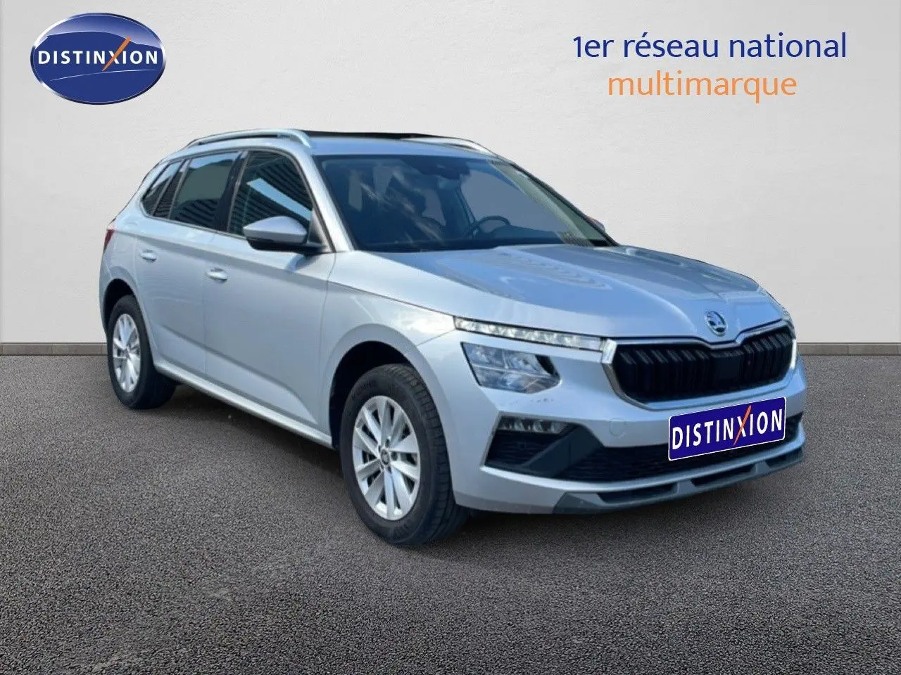 Vue 3/4 avant d'un Skoda Kamiq gris argent métal 2025 avec calandre noire et jantes alliage argentées.