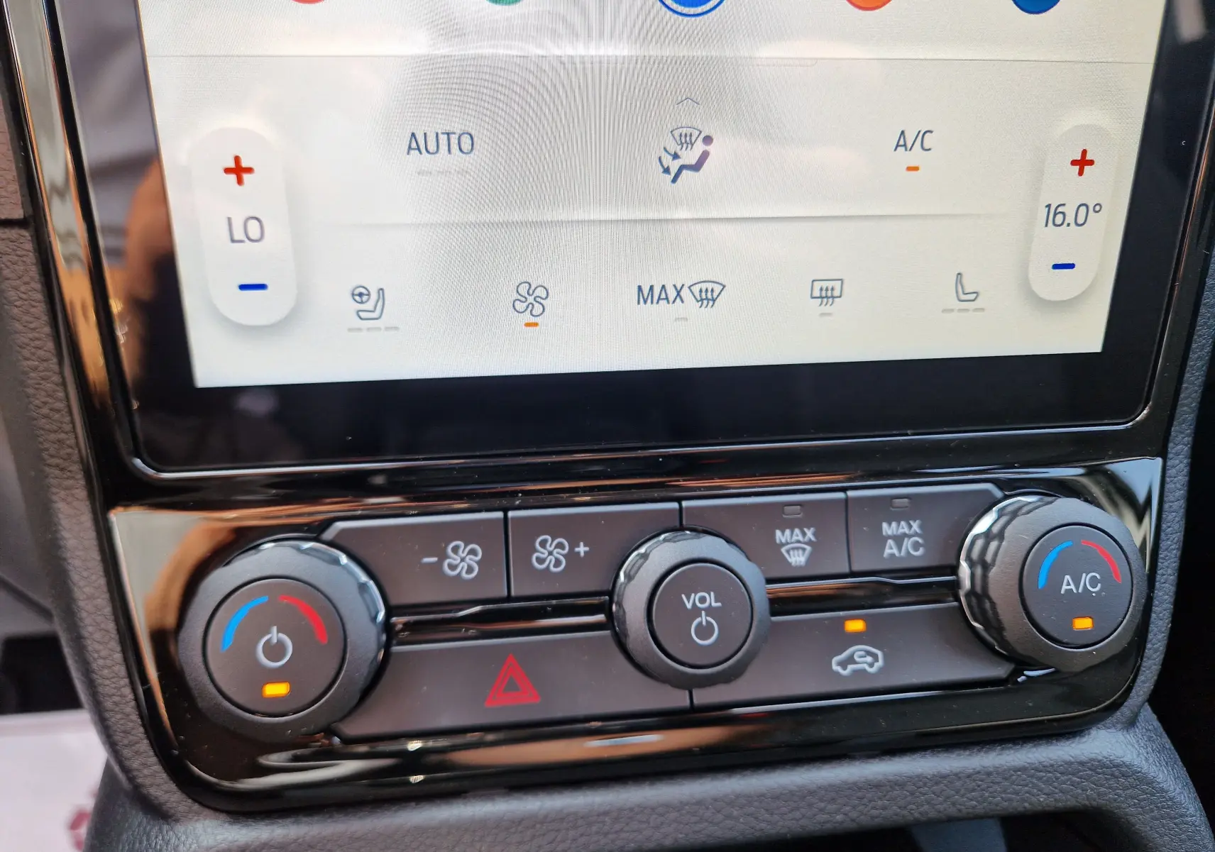 Gros plan sur la console centrale du Ford Ranger Super Cabine gris Iconic, montrant les commandes de climatisation et volume.