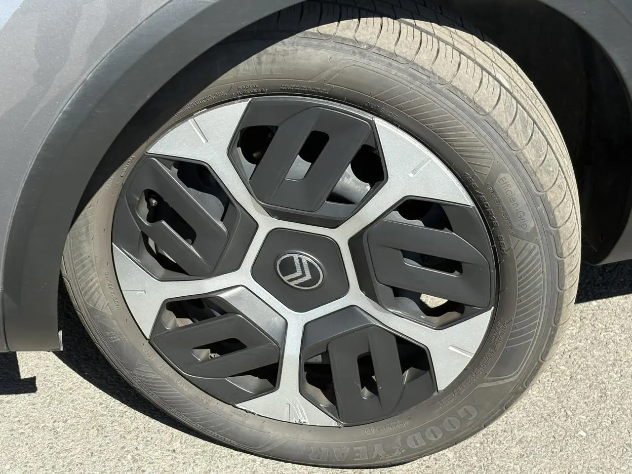 Gros plan sur la roue avant droite d'une Citroën C4 Hybrid 145 gris Mercury avec jante au design géométrique noir et argent.