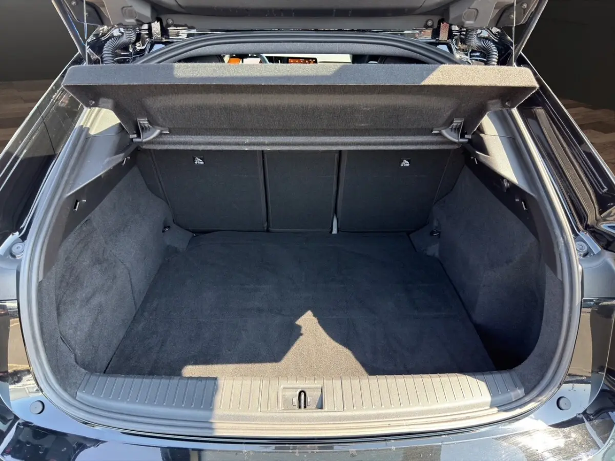 Coffre ouvert vu de l'arrière d'une Renault Rafale noire 2025, montrant l'espace de chargement vide et la moquette noire.