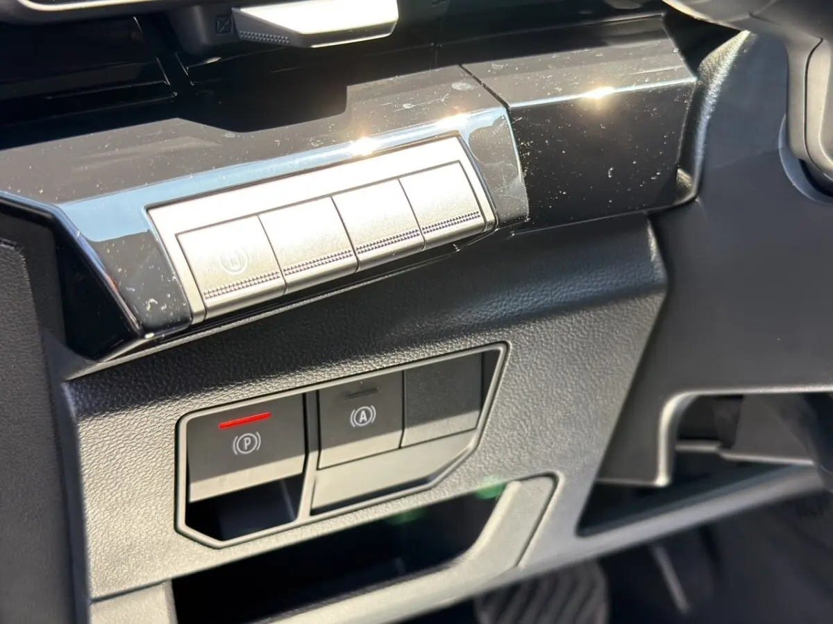 Détail intérieur côté conducteur du Renault Rafale 2025 noir, montrant les commandes électroniques du frein à main et du démarrage.