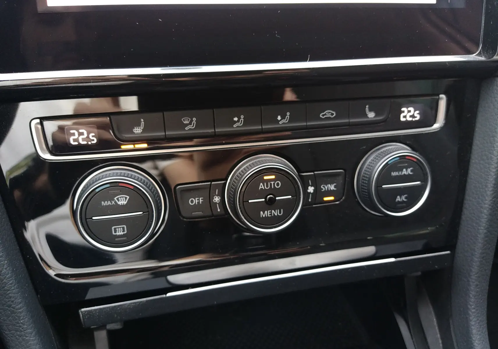Gros plan sur la console de climatisation digitale d'une Volkswagen Golf gris reflet d'argent, avec affichage à 22,5°C.