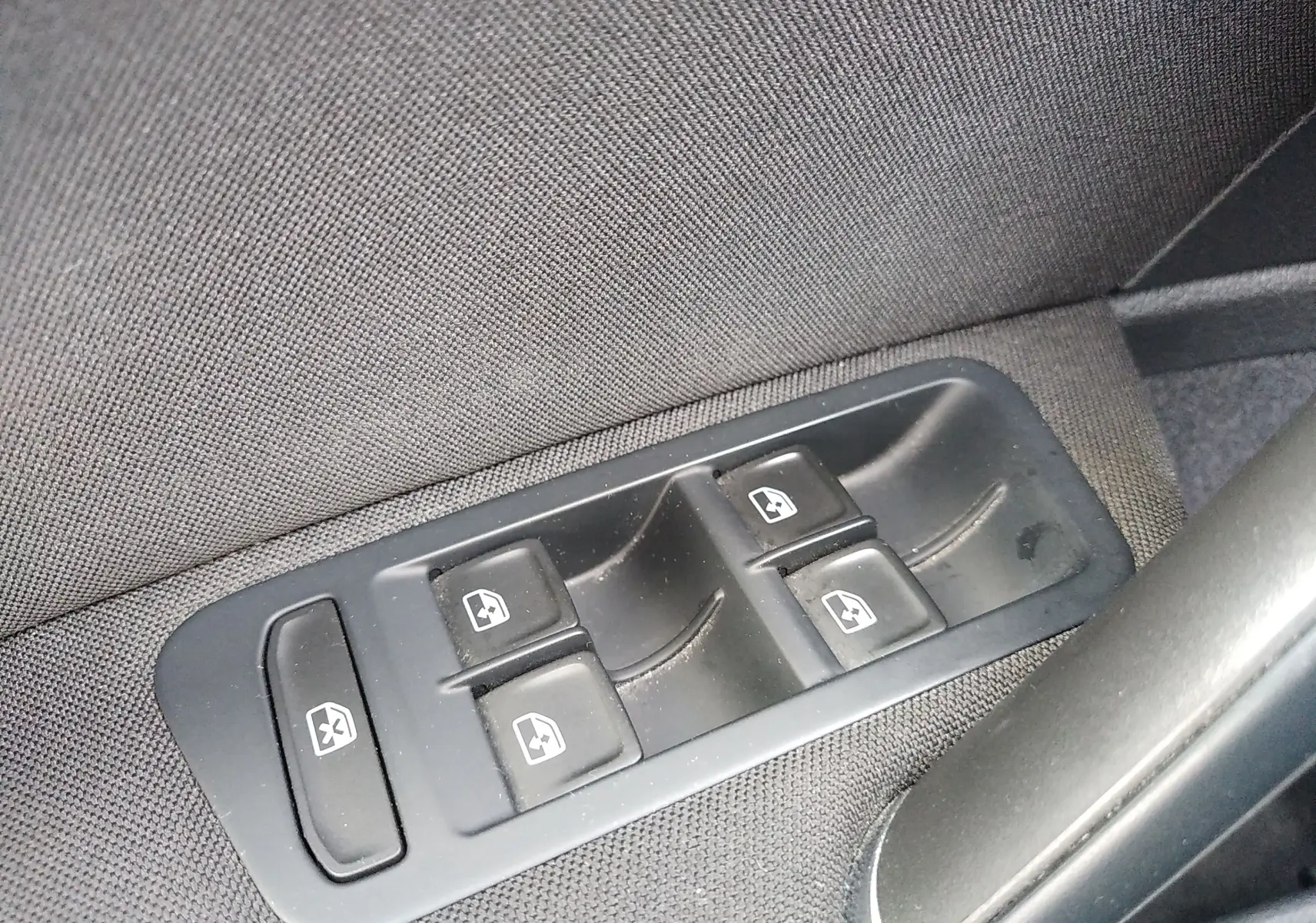 Gros plan sur les commandes des vitres électriques côté conducteur d'une Volkswagen Golf gris reflet d'argent de 2019.