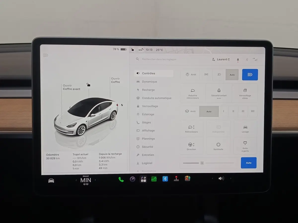 Écran tactile central affichant la Tesla Model 3 blanche en vue 3/4 avant avec commandes et réglages du véhicule.