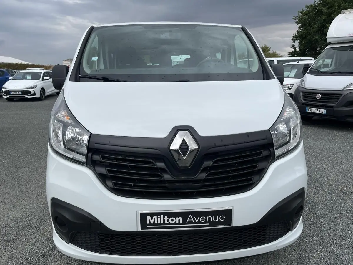 Vue frontale d'un Renault Trafic Fourgon blanc avec calandre noire et logo Renault bien visible.