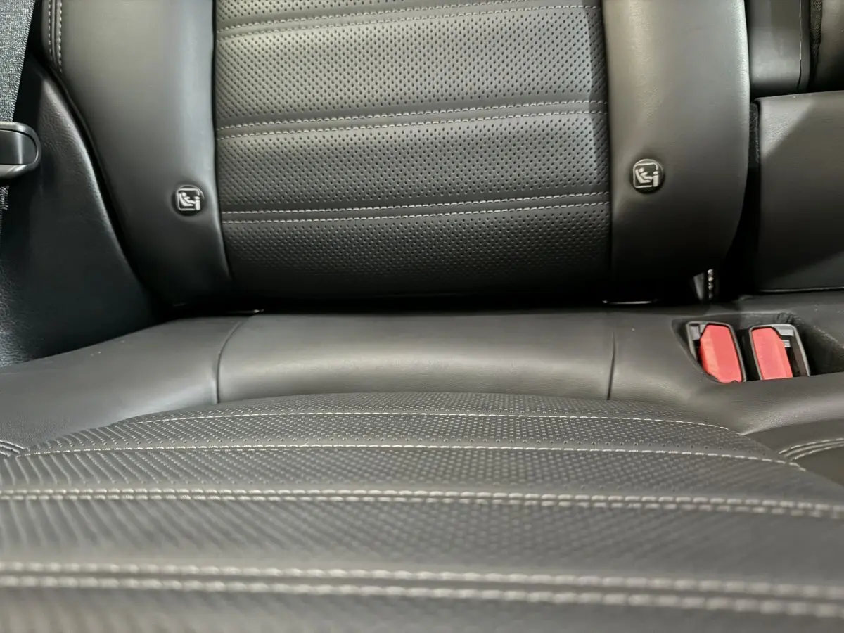 Gros plan sur la banquette arrière en cuir noir perforé avec ceintures rouges de l'Alfa Romeo Tonale hybride 2023.