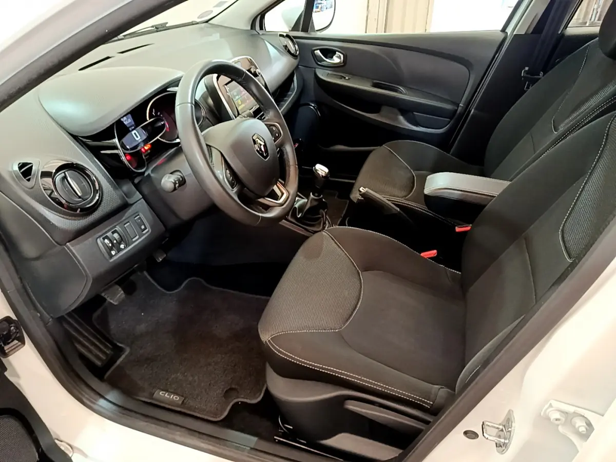 Intérieur côté conducteur de la Renault Clio Business blanche 2019, volant cuir et tableau de bord avec écran tactile.