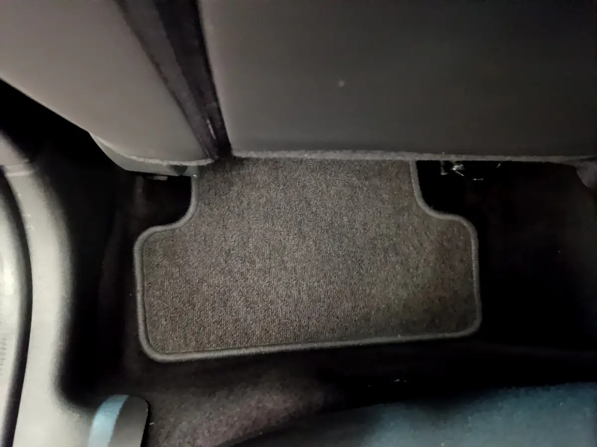 Tapis de sol gris foncé côté passager arrière dans l'habitacle d'une Renault Clio Business blanche de 2019.